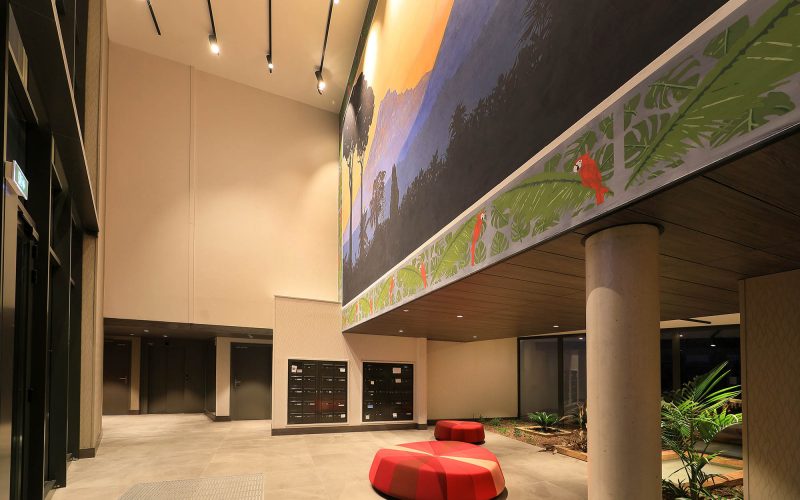 Hall résidence avec fauteuils ronds rouges et peinture Pic Saint-Loup